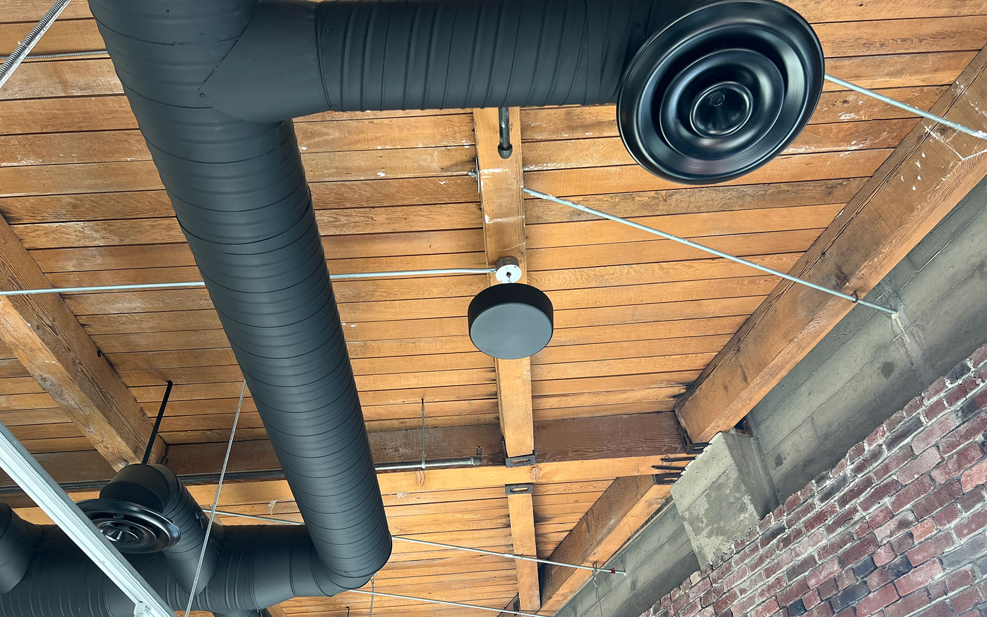 Open ceiling showing hanging pendant masking speaker